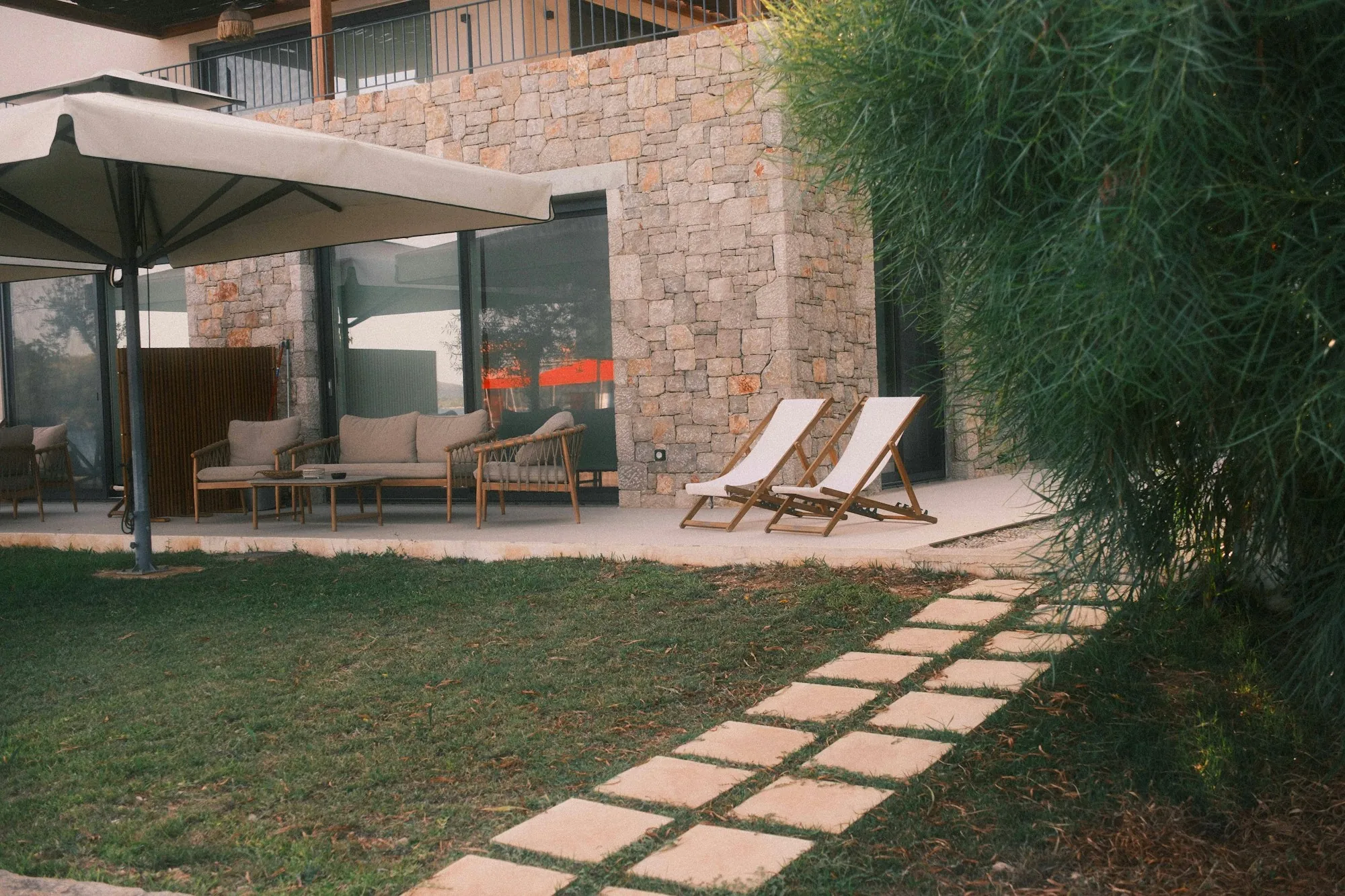 Concrete stepping pads leading across a lawn to a patio