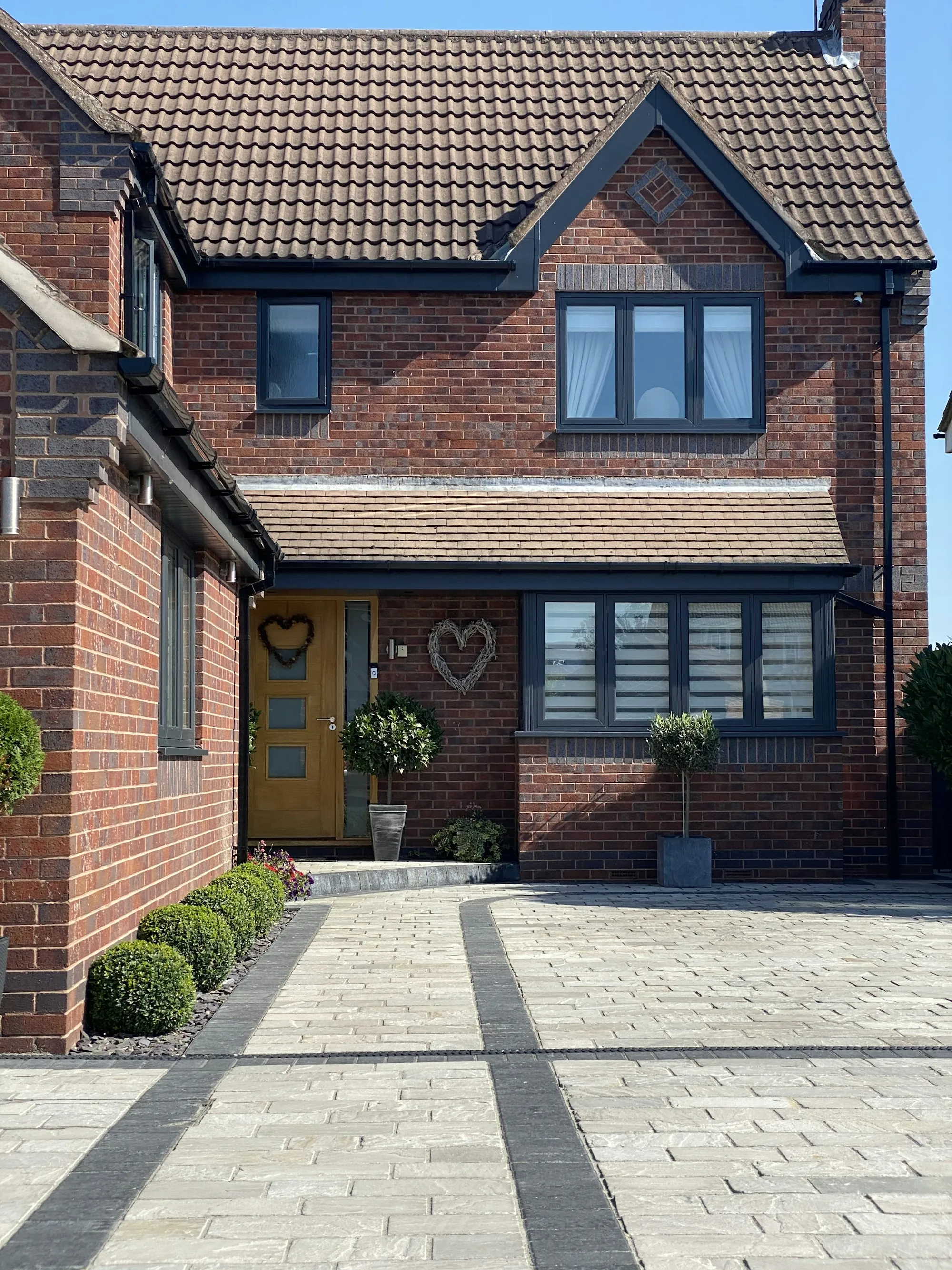 Brick home entrance with a paved front walk