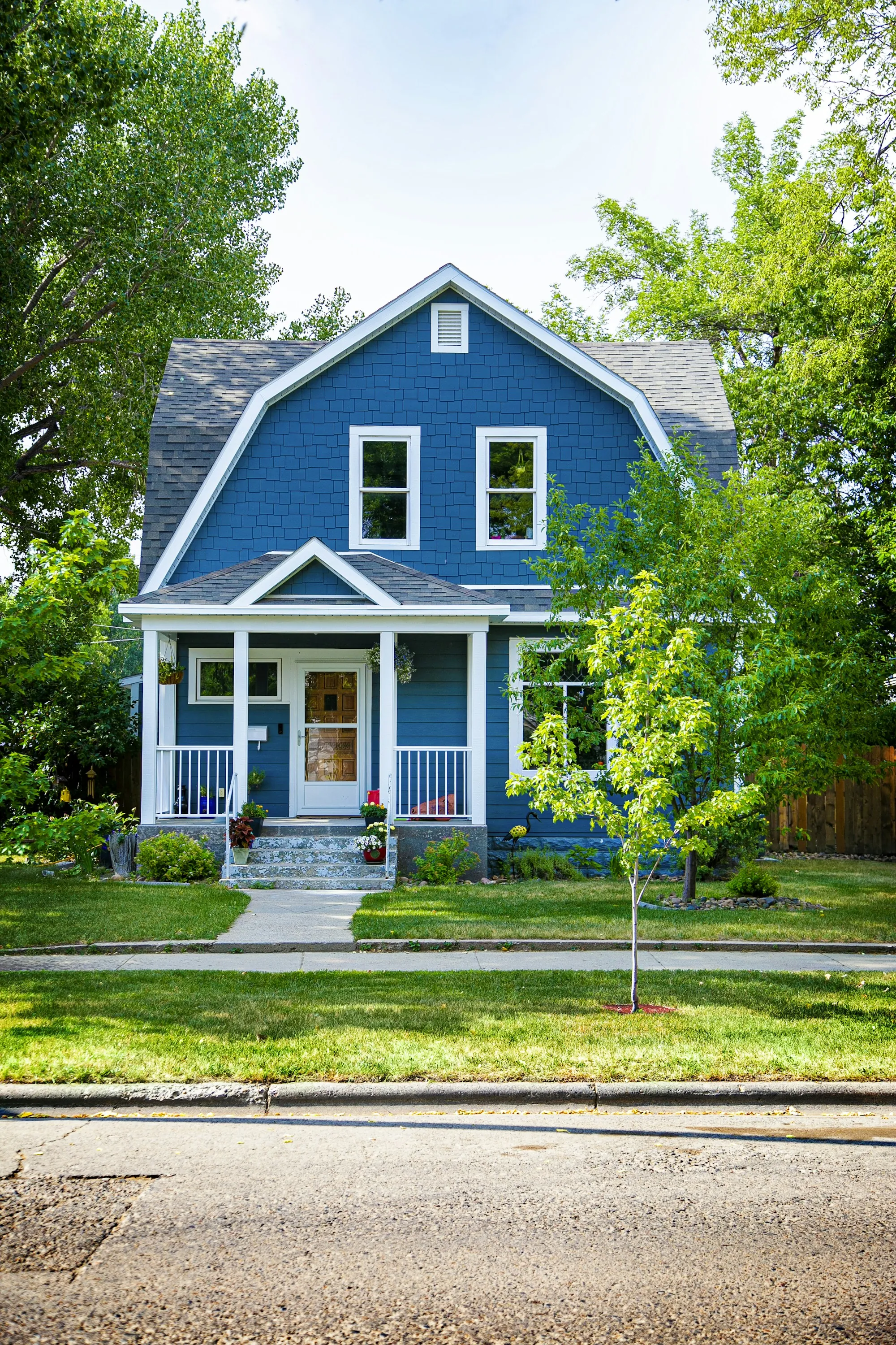 Blue house with a front walkway and steps to the porch